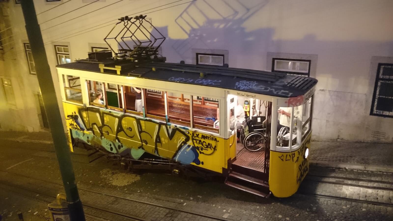 A yellow tram travelling up a steep hill