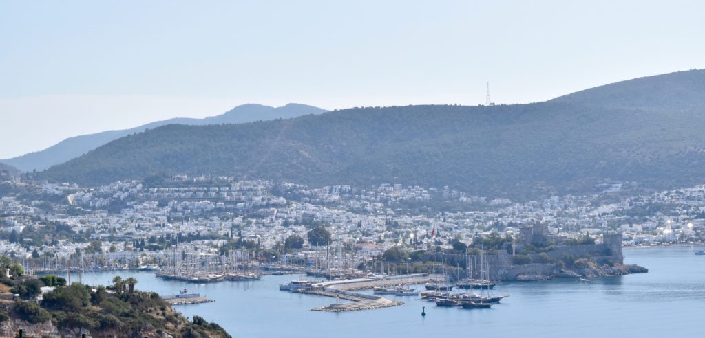 the beautiful castle on the water in Bodrum with the hills behind