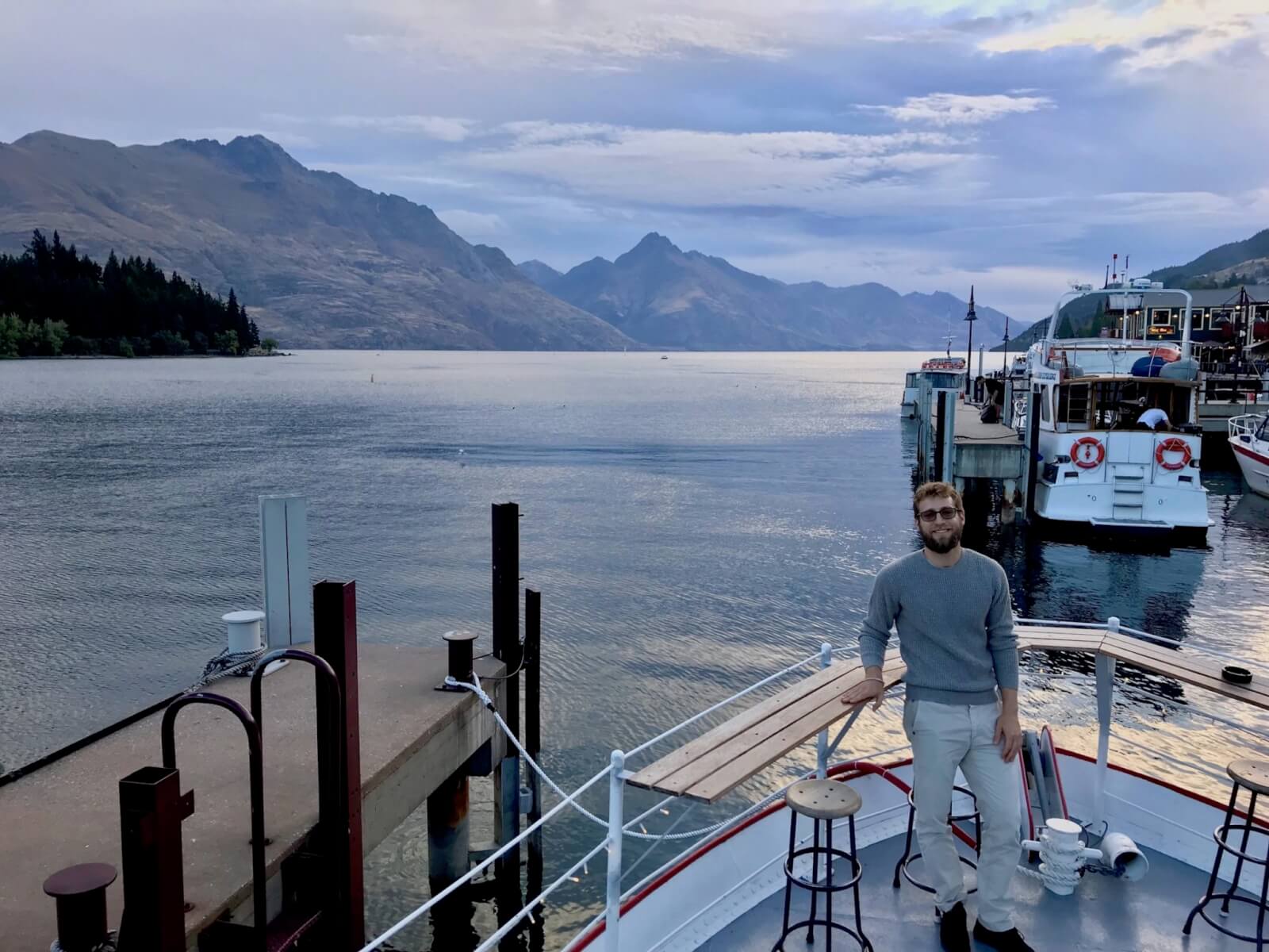 Enrico on a boat with the lake and mountains in the background