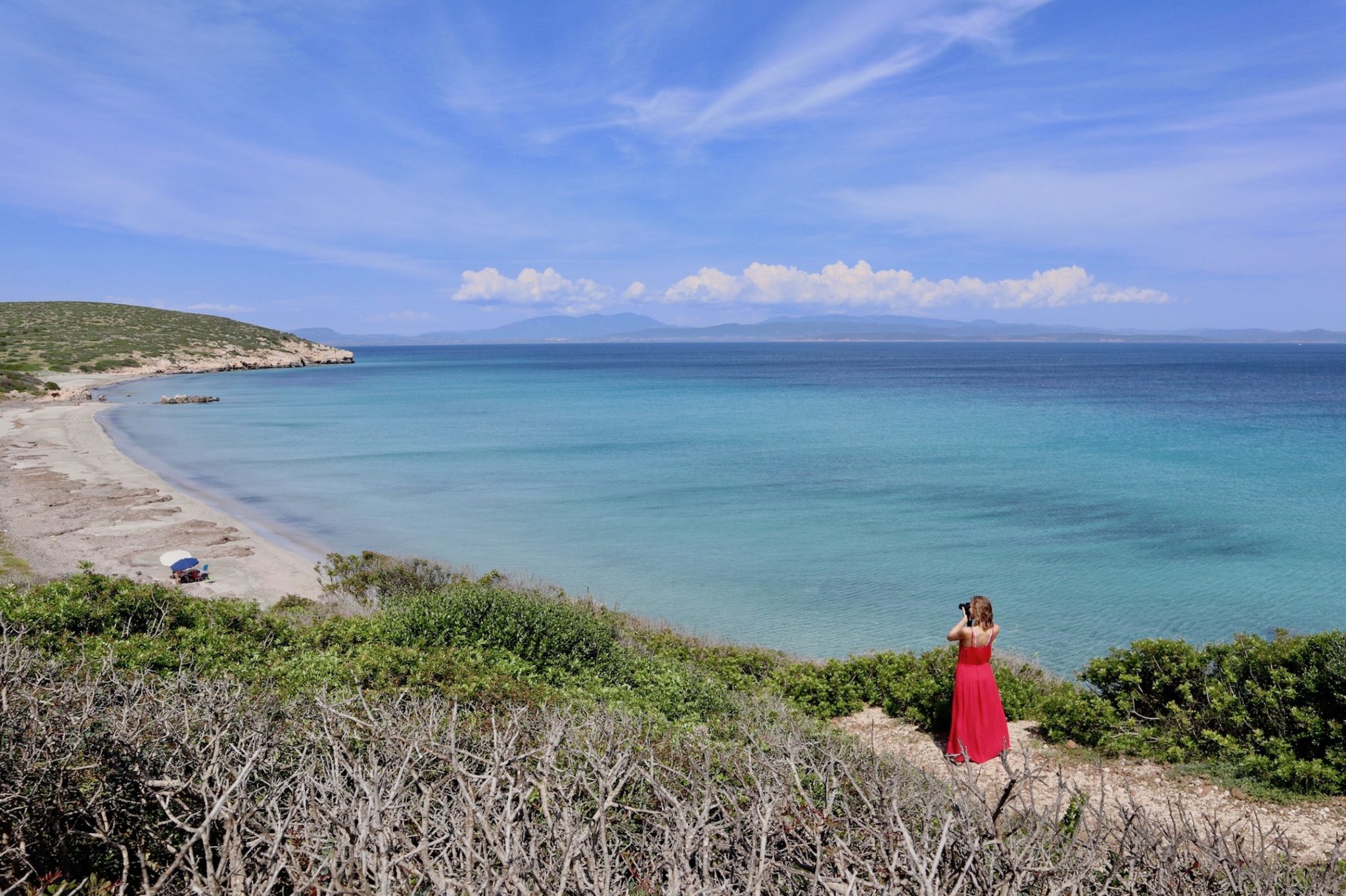 Hayley taking a photo of an empty sand beach 