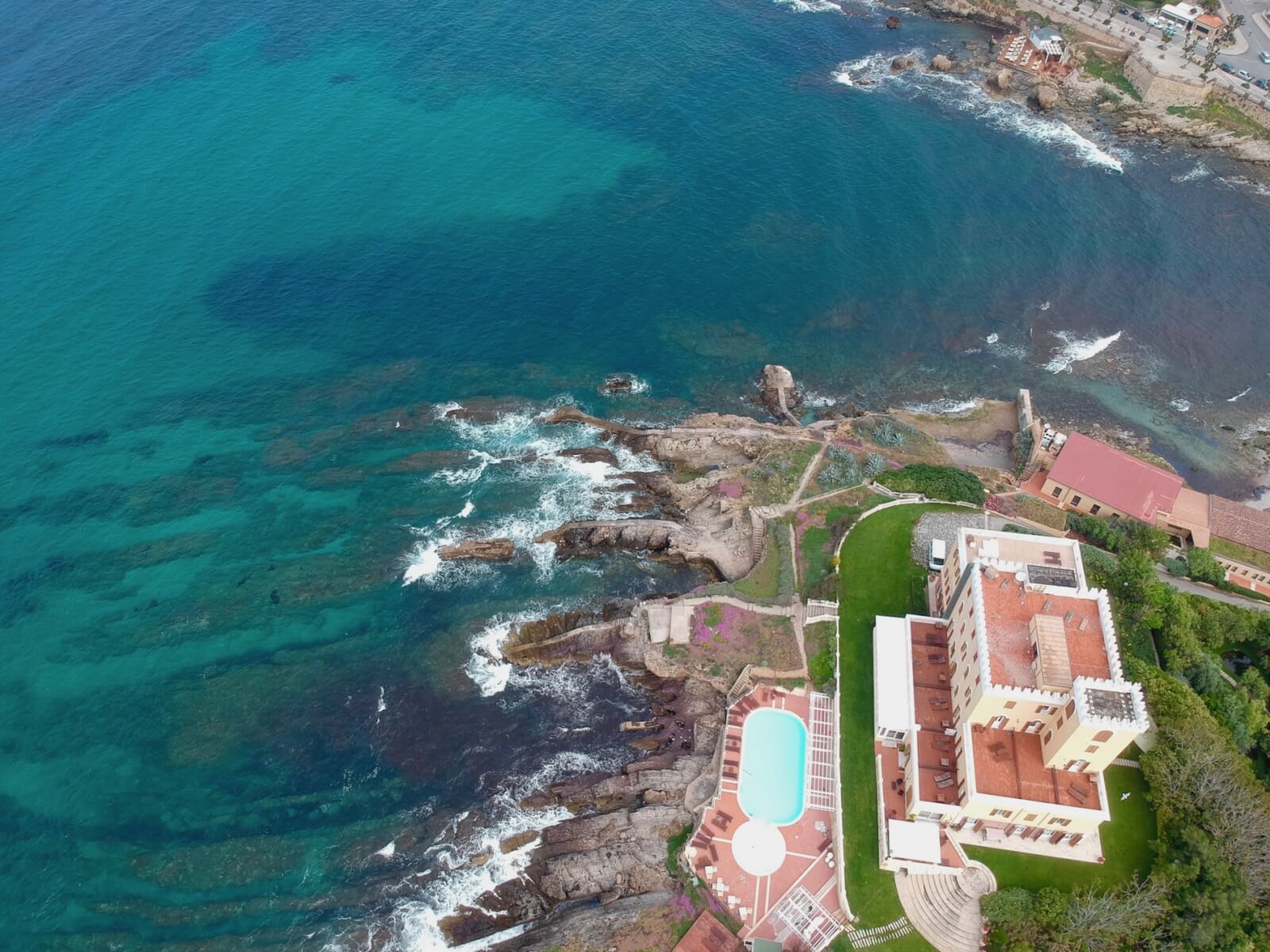 An aerial view of a coastal hotel with a pool