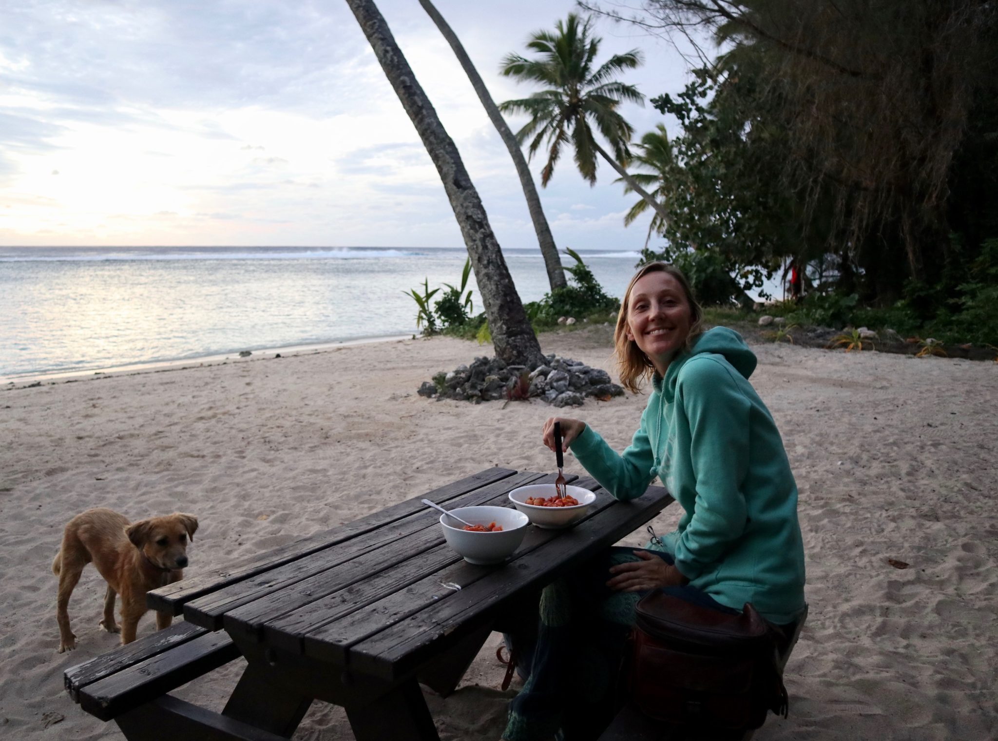 Hayley eating pasta on the beach in Rarotonga