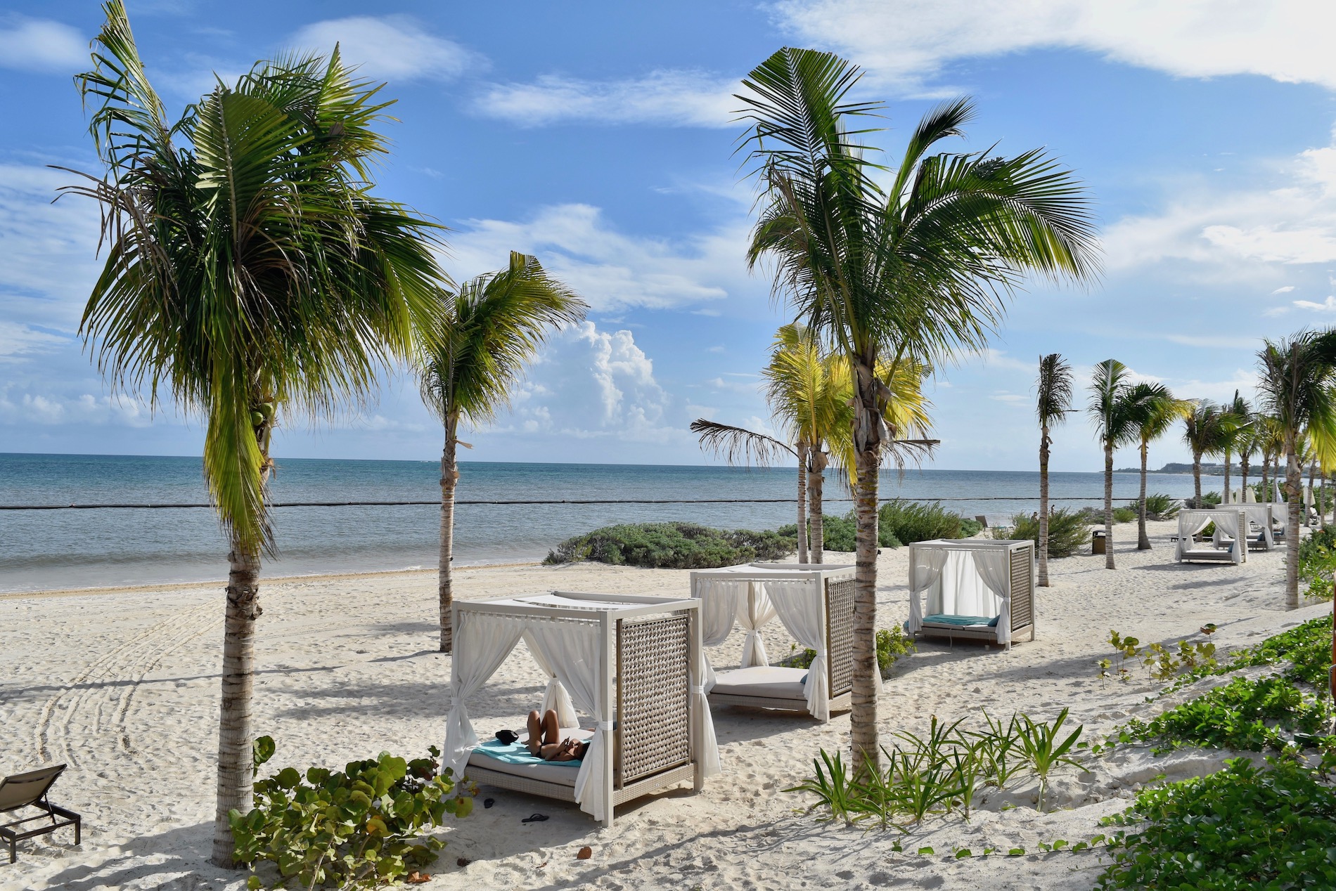 a white sand beach with day beds 