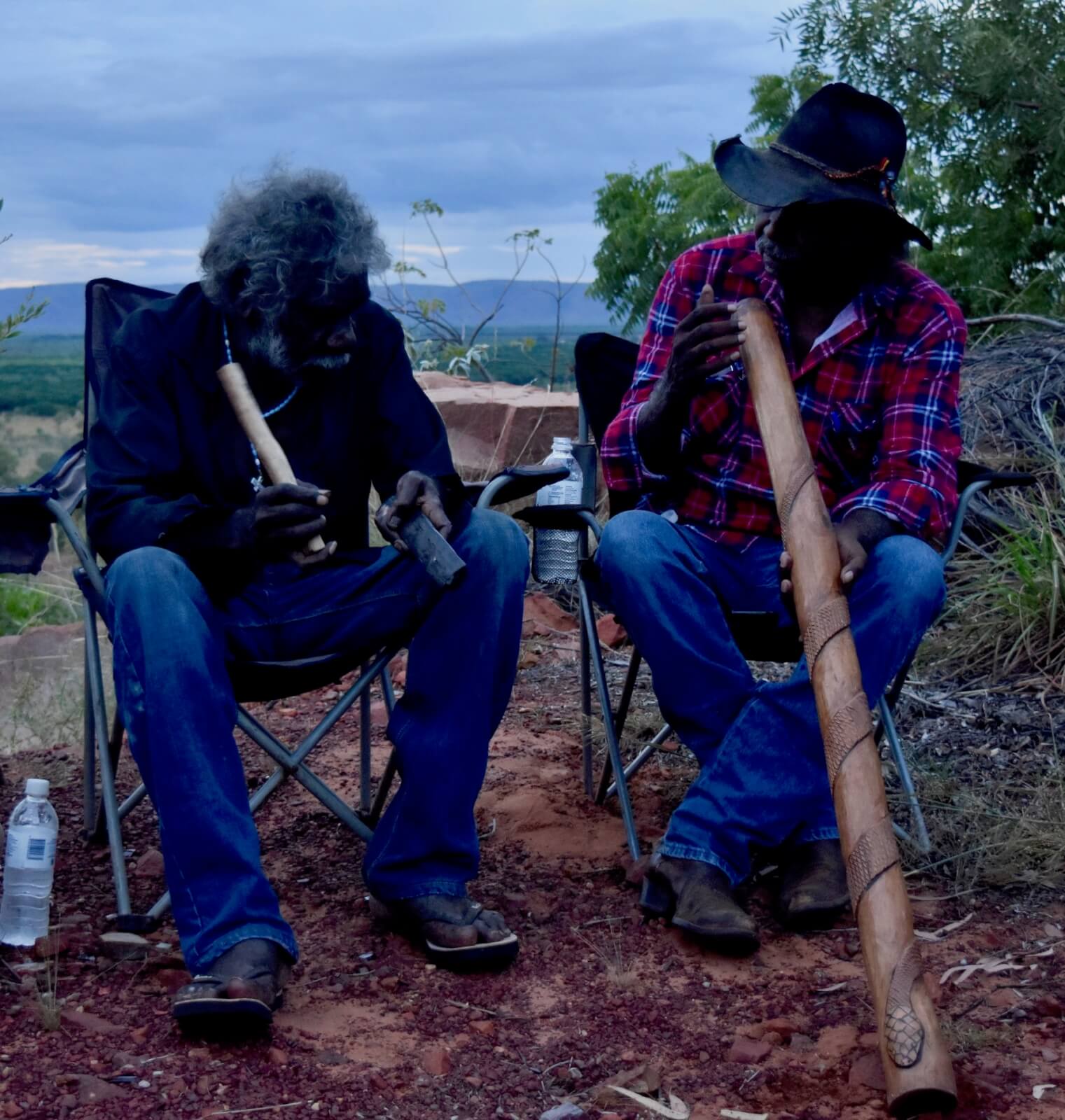 two men playing aboriginal music on the didgeridoo and clapsticks 