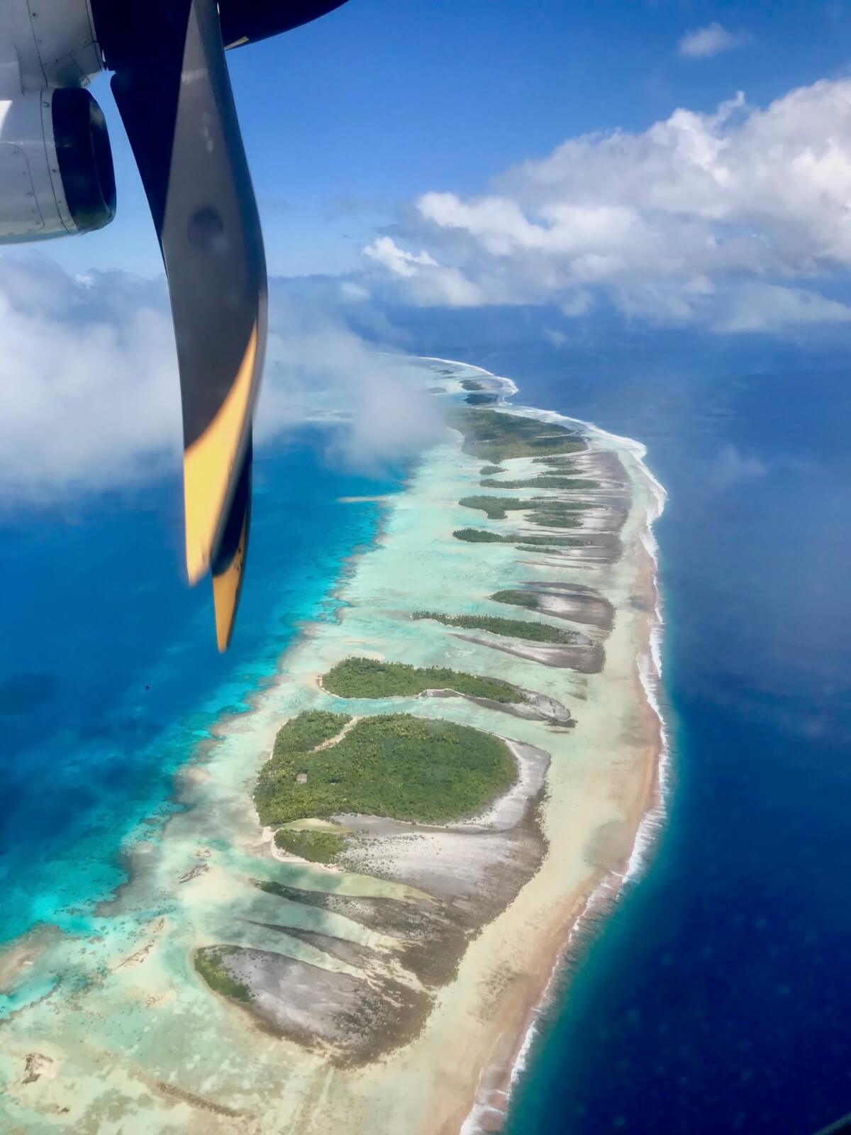 The view over a sandy atoll from a propeller plane