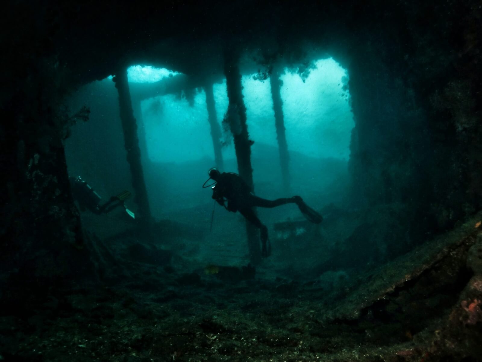A diver swimming through the Liberty shipwreck