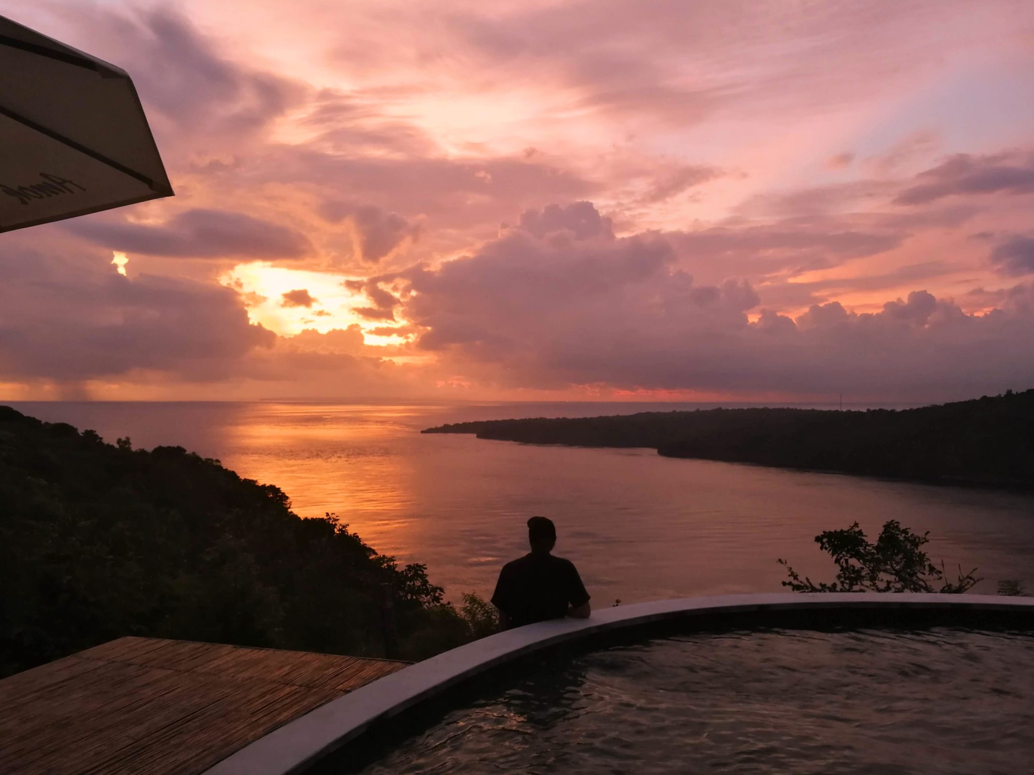 The sun setting over the ocean from the pool