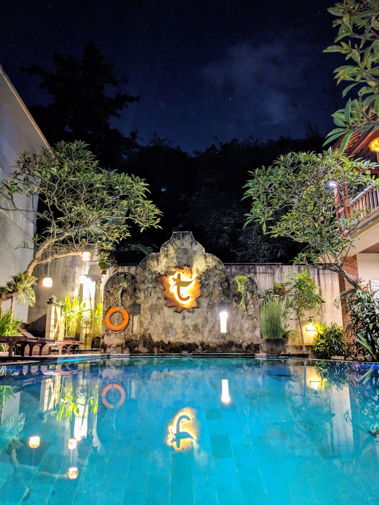 A stunning swimming pool lit up at night. Ubud Guide
