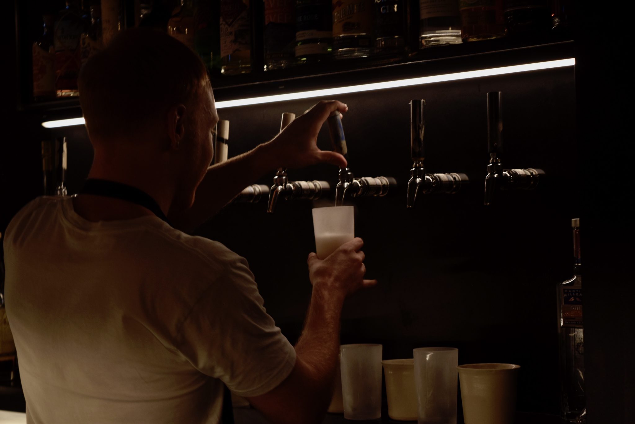 A barman pouring drink from the taps 