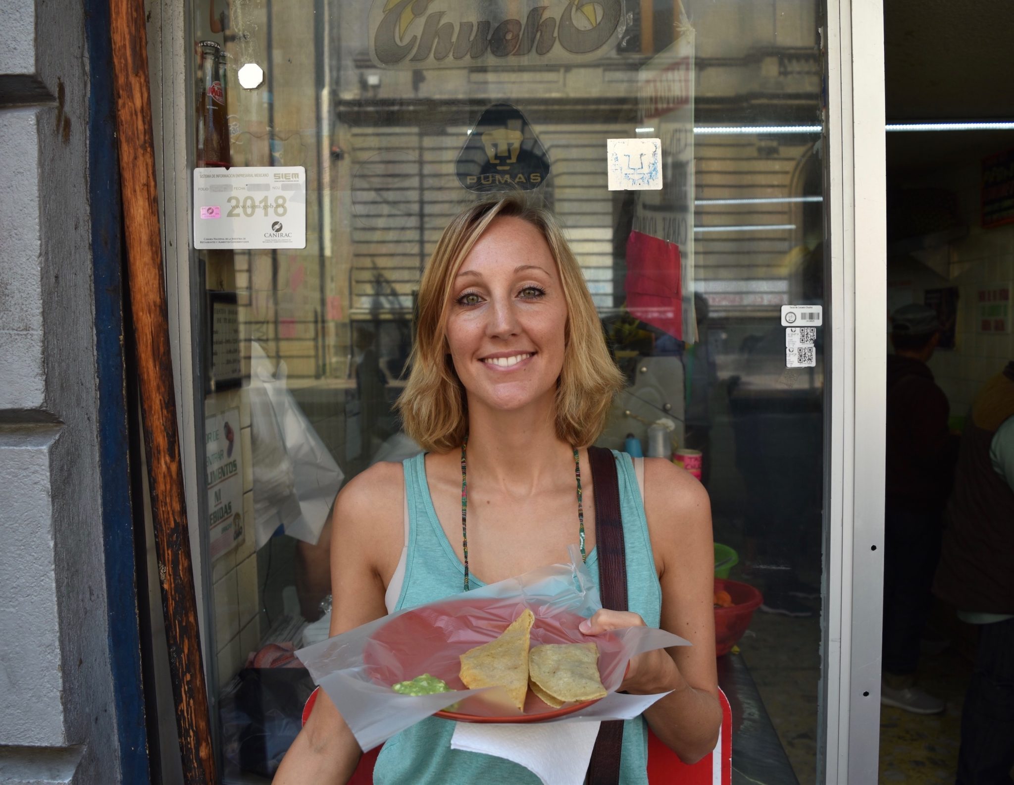 Hayley with tacos in front of the taco shop 