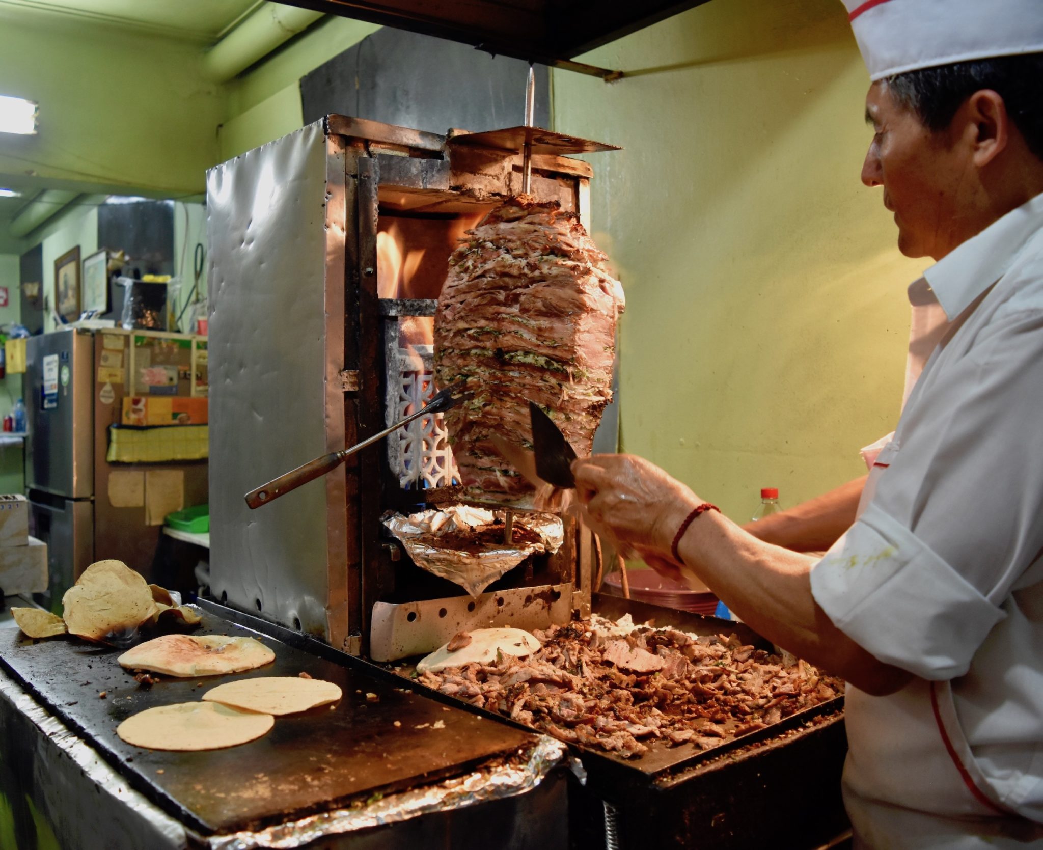 A man cutting meat from the trompo