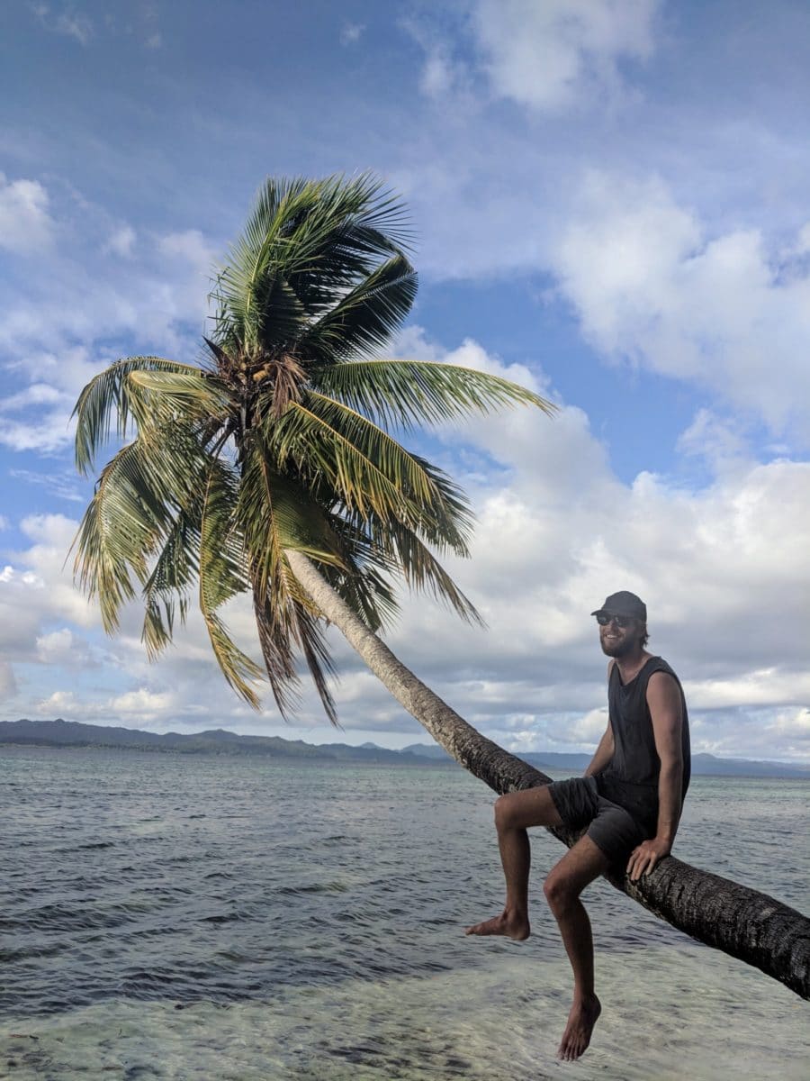 James sitting on a overhanging coconut tree 