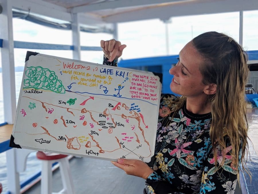 Sarah holding up a dive briefing board