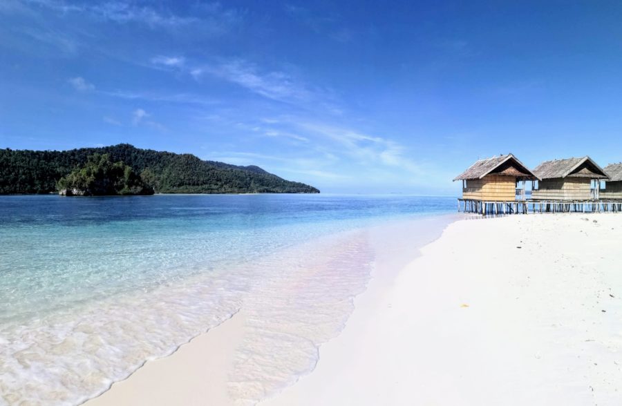 white sands and crystalline waters, with a few stilted bungalows