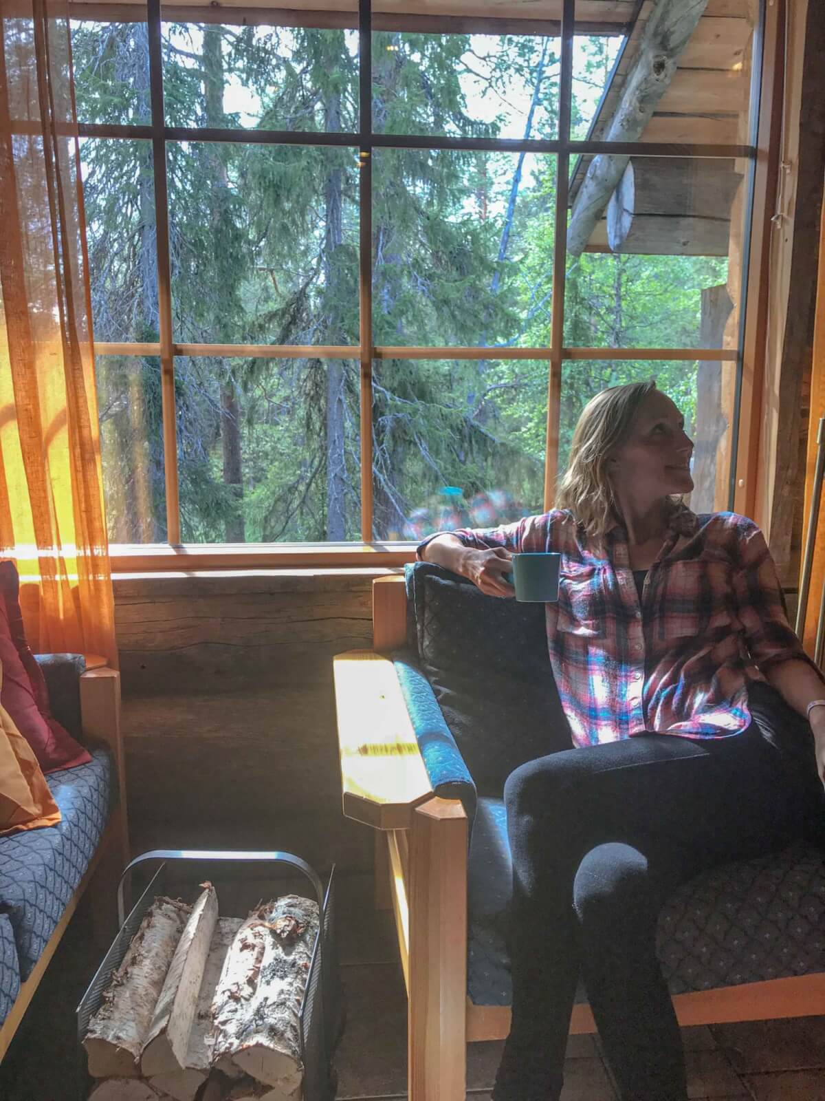 Hayley relaxing with a hot drink inside the wood cabin 