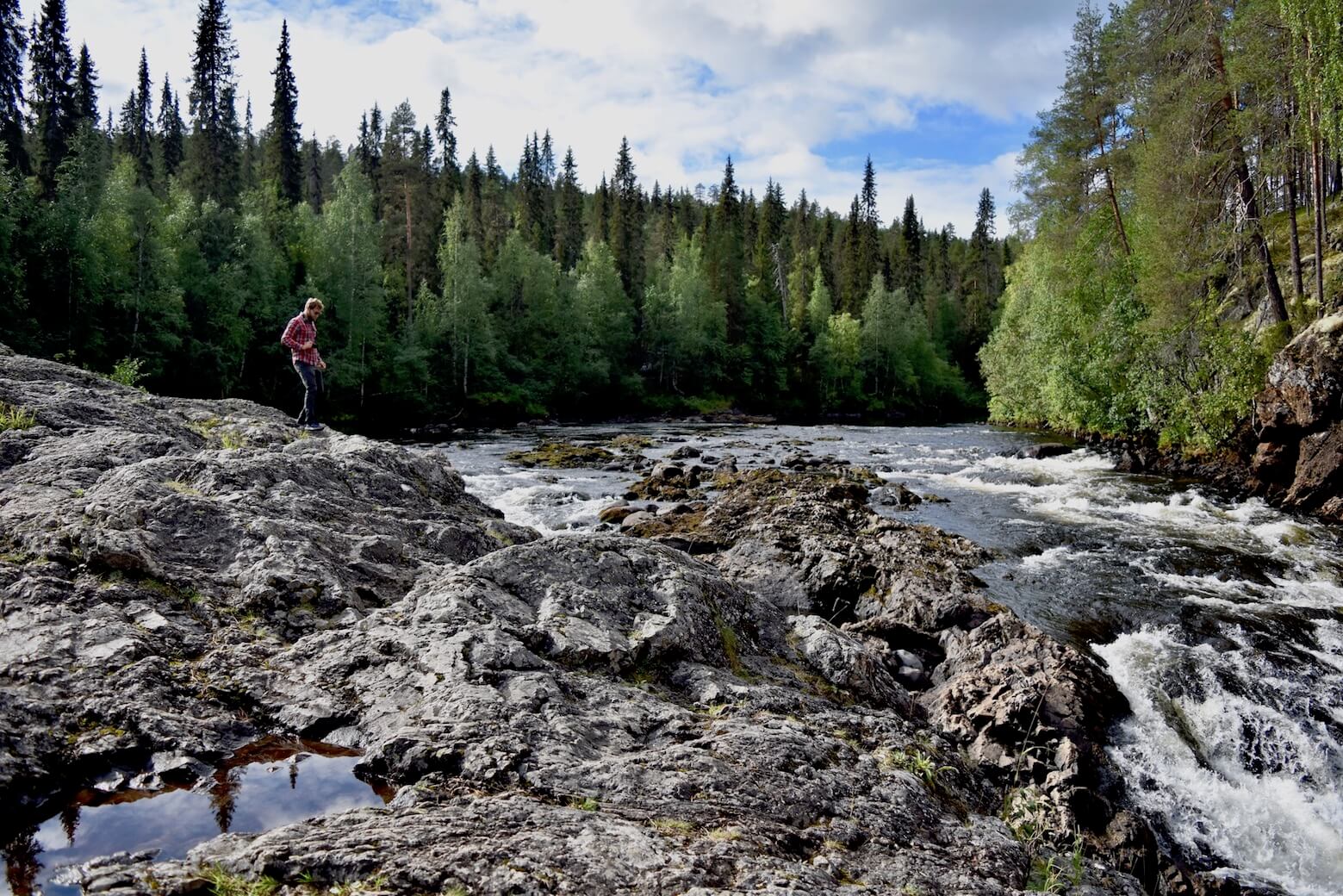 Enrico hiking across the rocks by a river