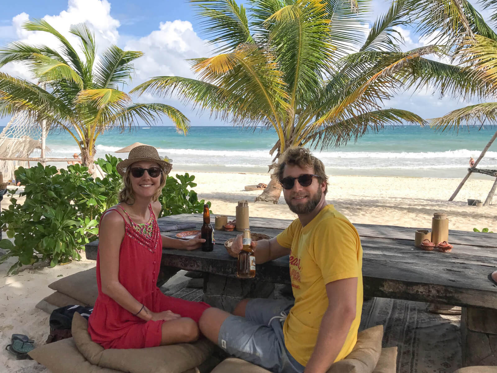 Hayley and Enrico drinking a beer on the beach in Tulum 