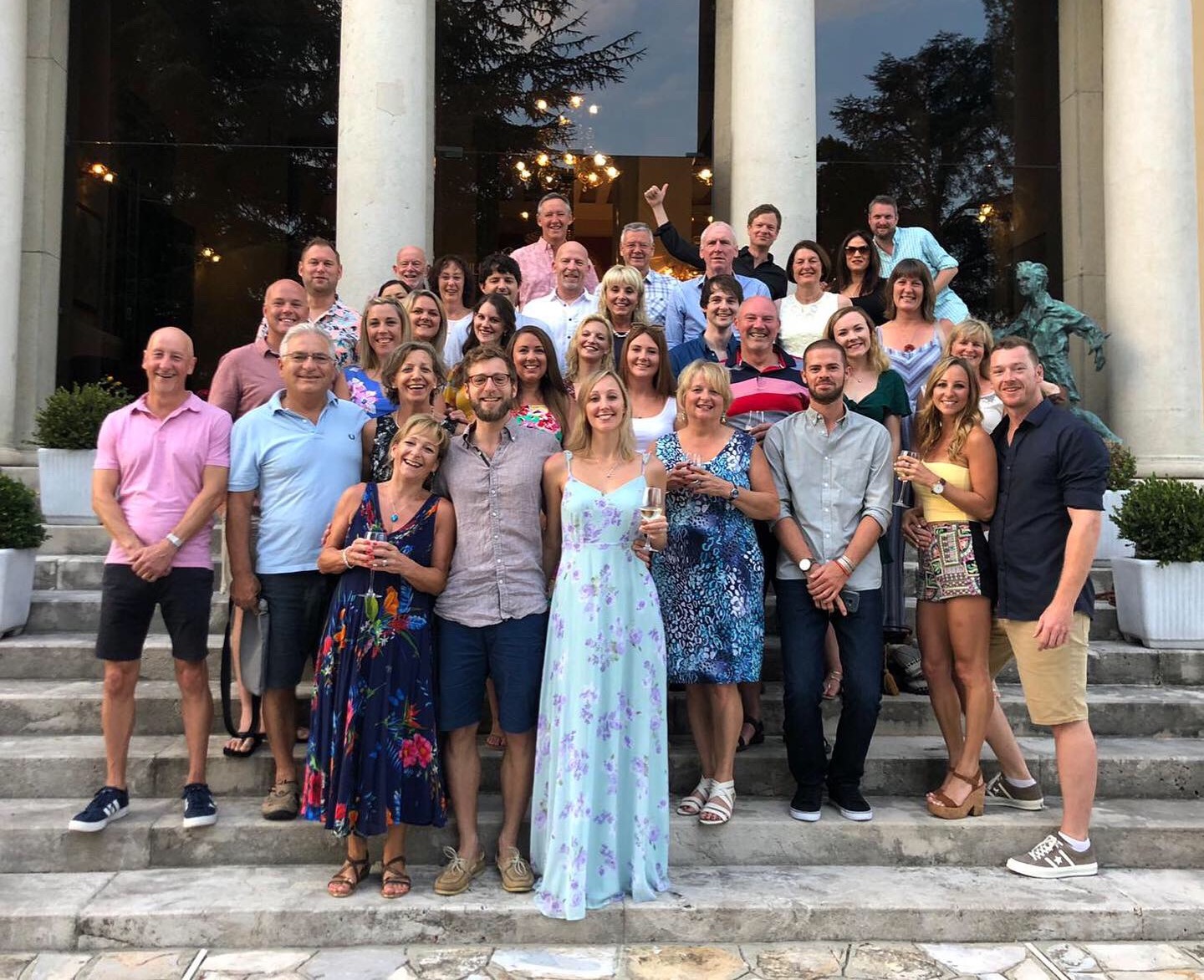 A group of friends and family in front of a grand hotel entrance 