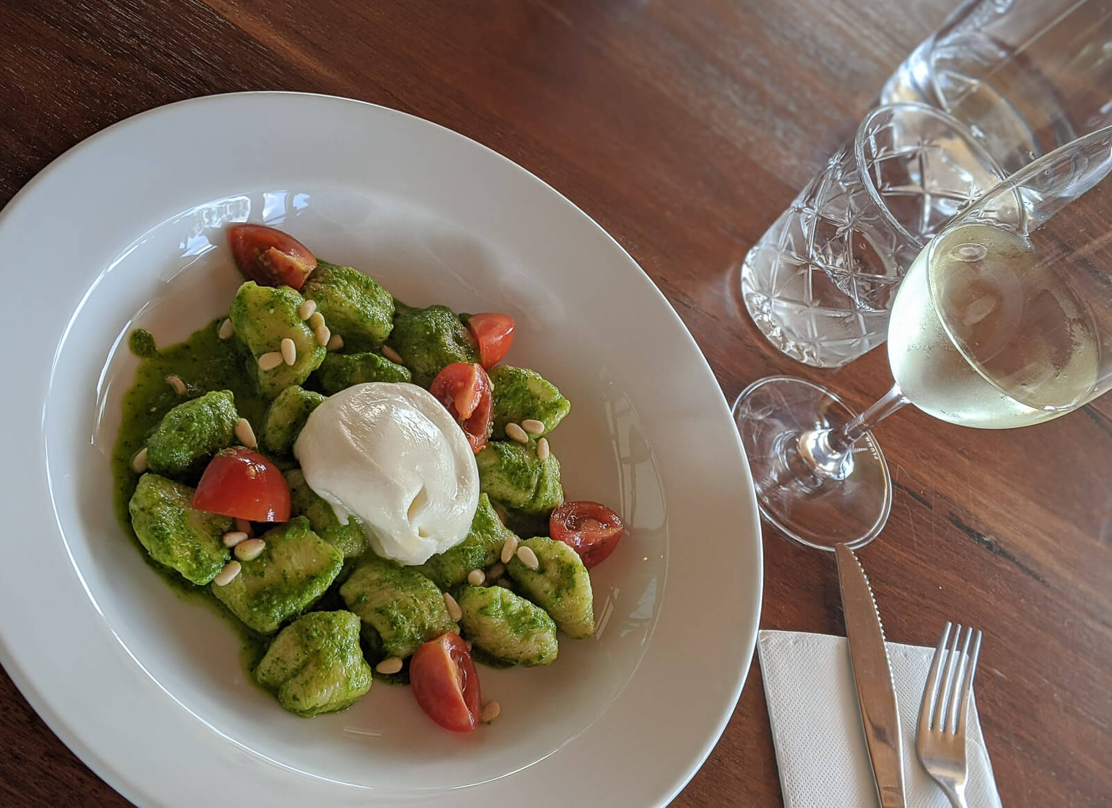 A dish of gnocci, pesto and burrata 