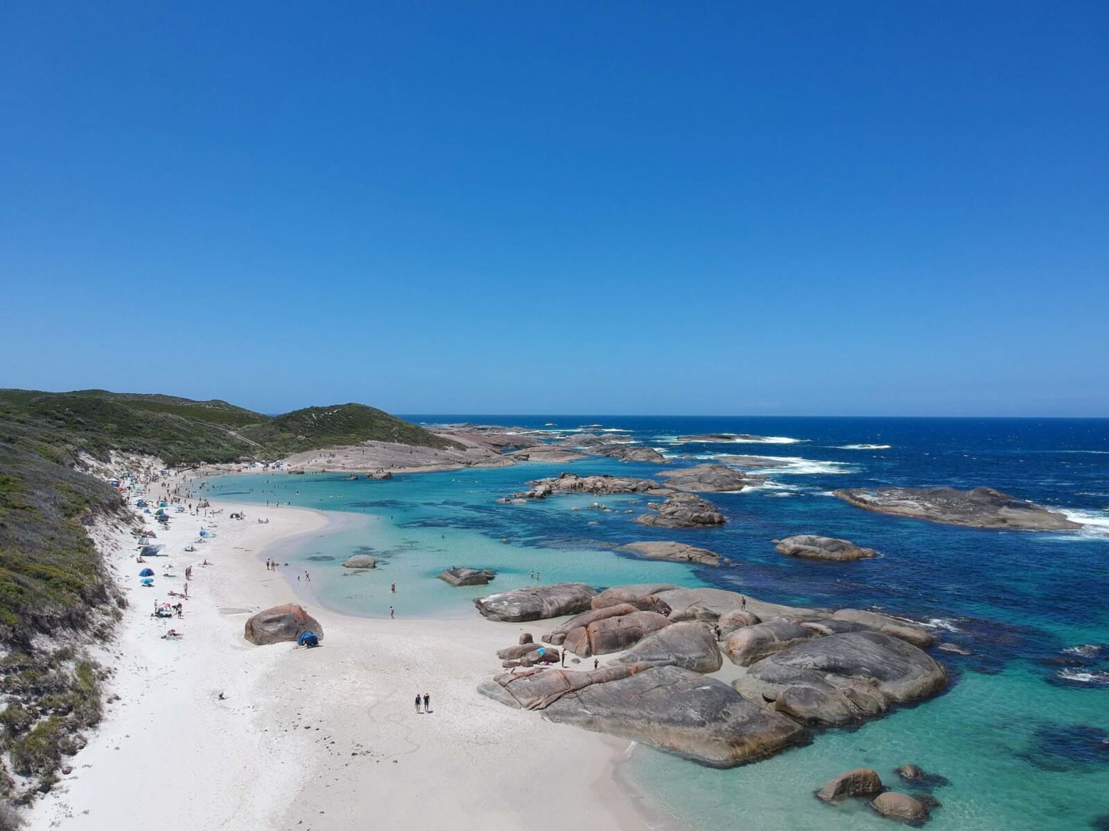 An aerial view of blue and green water interspersed with rocks 