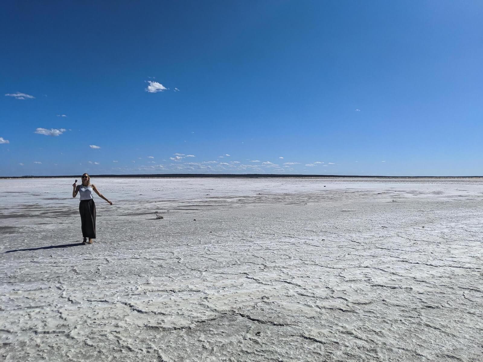 Hayley eating an ice cream standing on a salt lake 