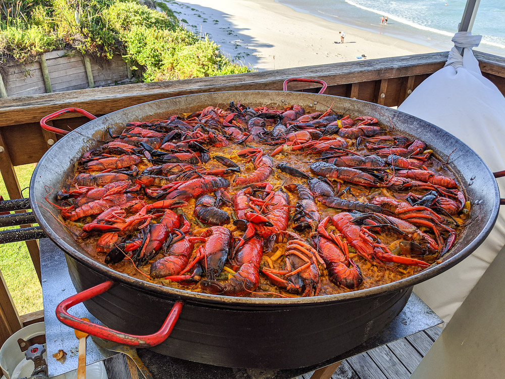 A huge paella dish on a balcony overlooking the beach 