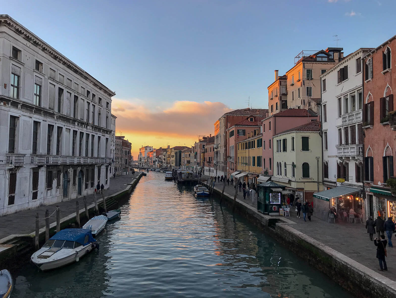 A canal in Venice, with colourful houses either side 