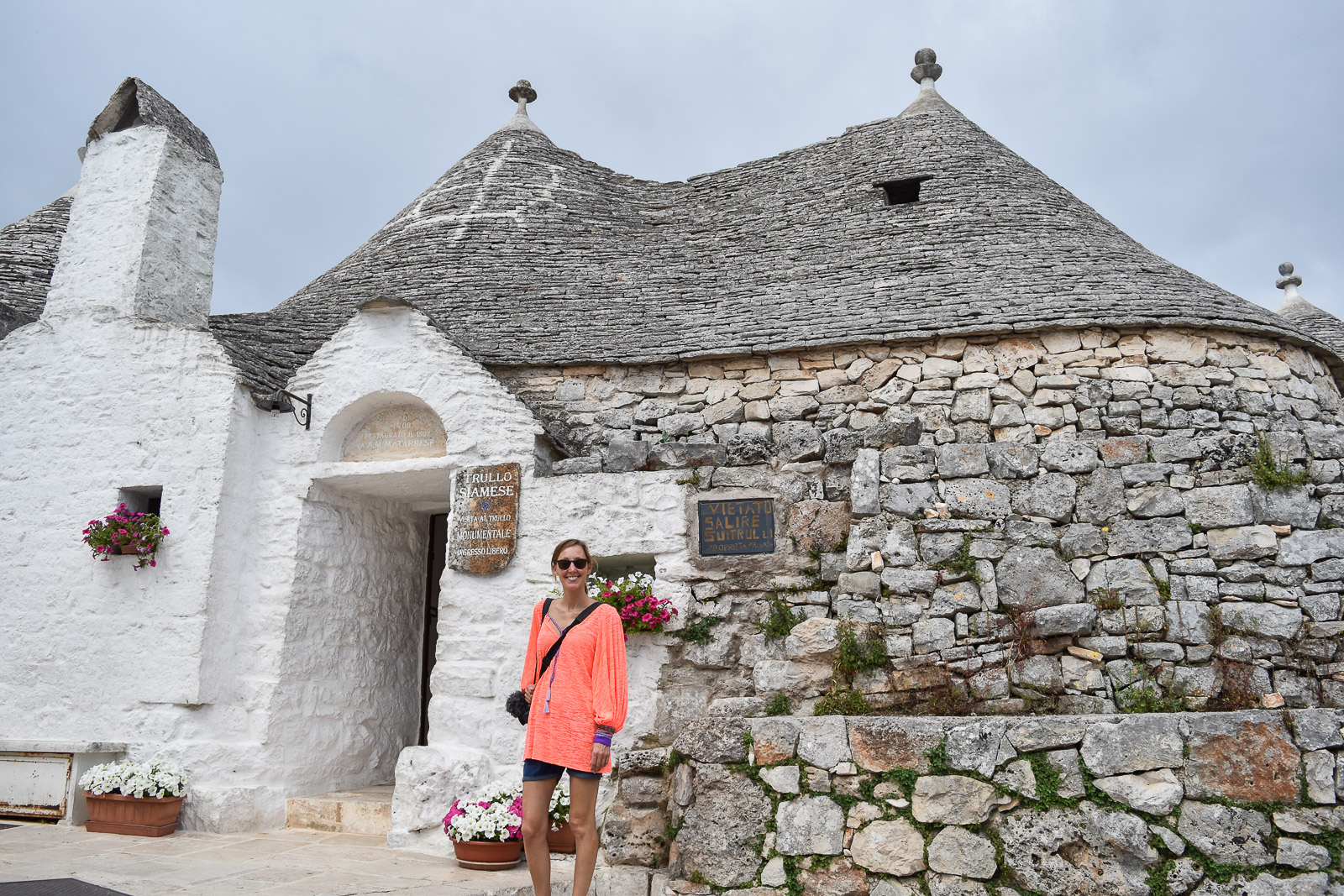 Hayley standing in front of a double coned Trullo in Alberobello. A must visit place on your Puglia itinerary. 