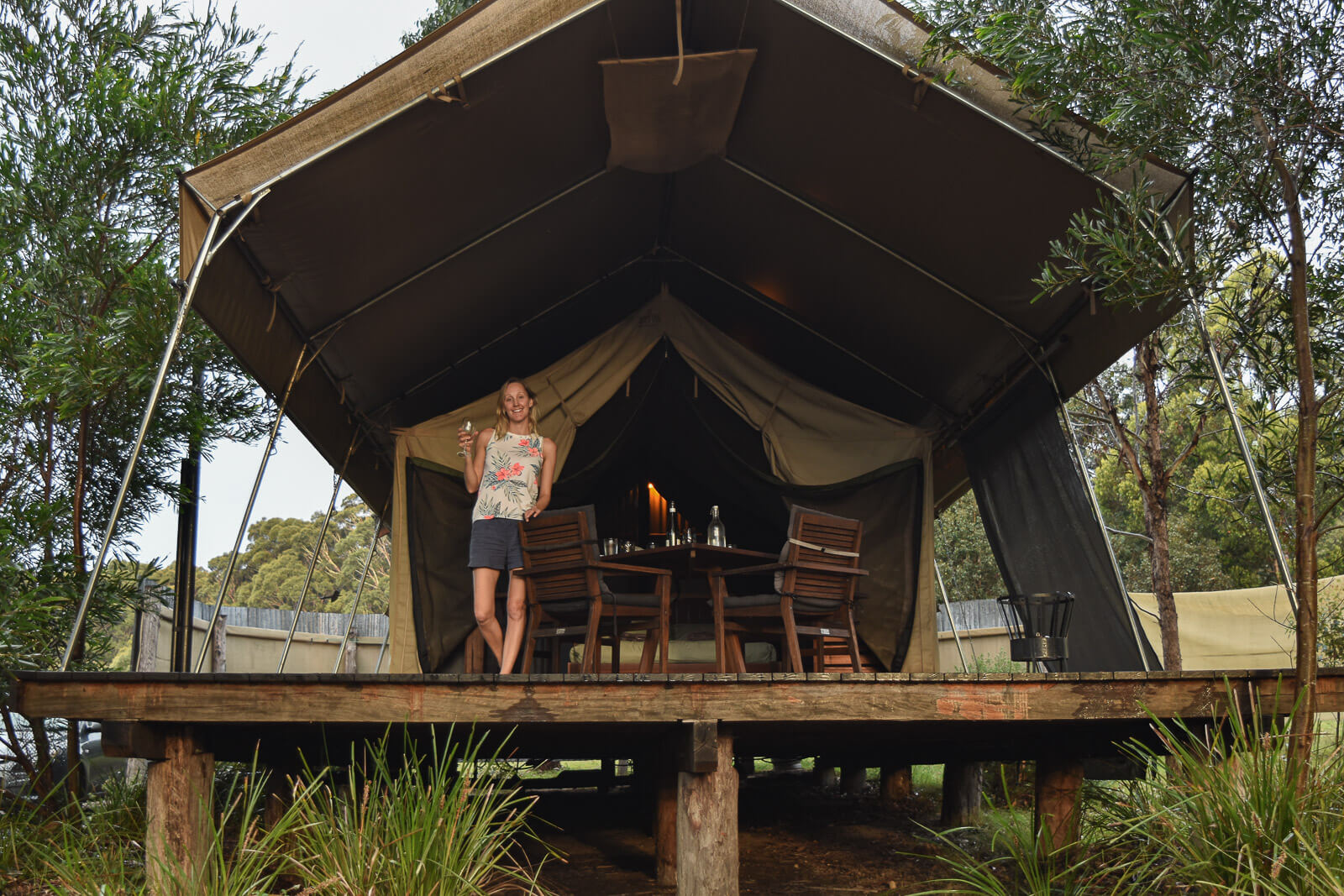 Hayley stands on the deck on the tent 