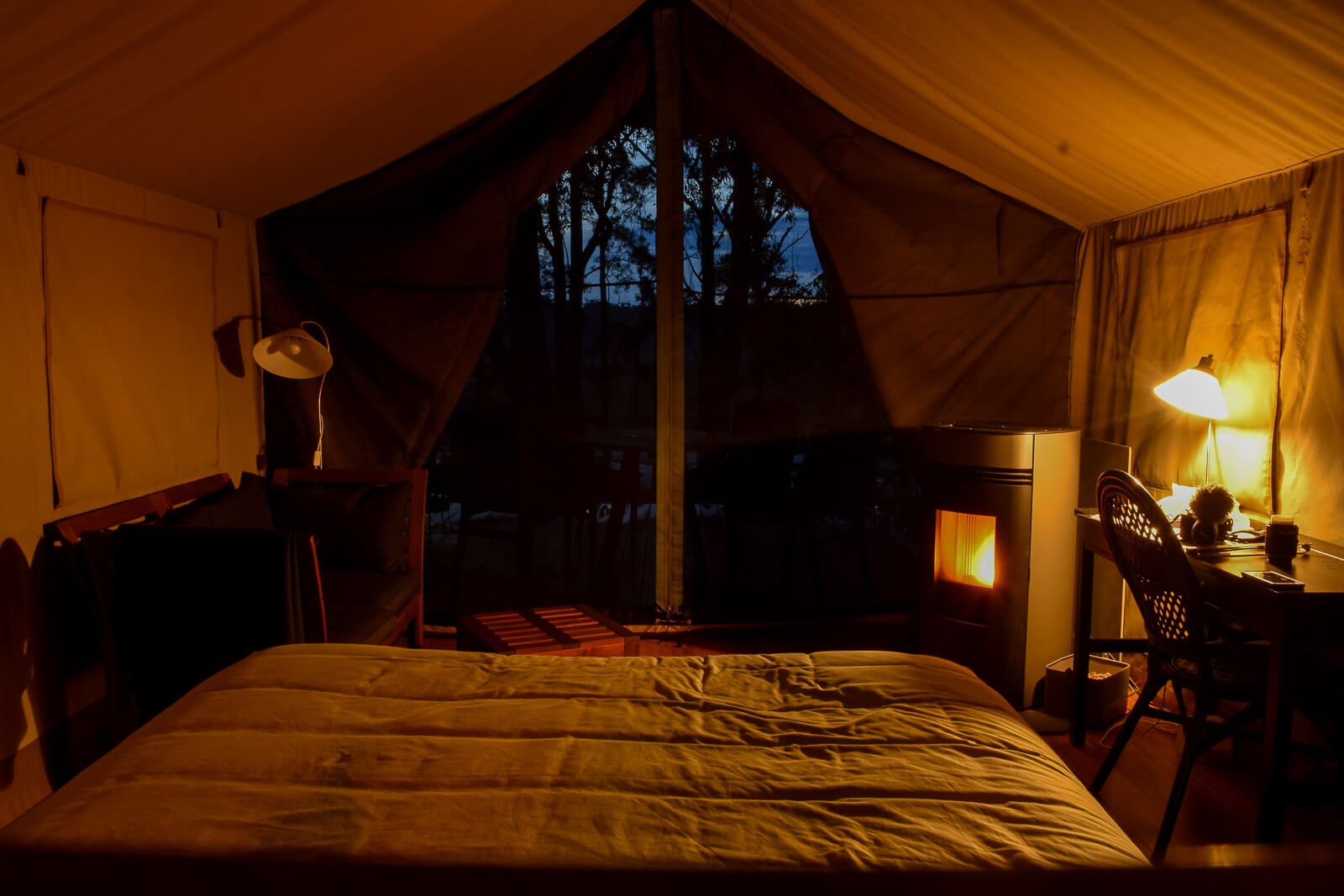 The view from the bed looking outside the tent and a fire in the corner