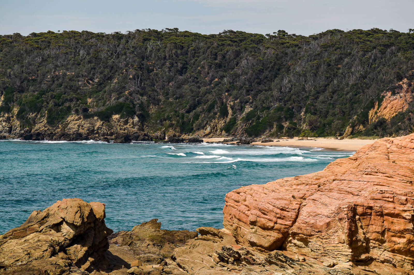 Rocks sheltering a sandy beach in Bermagui