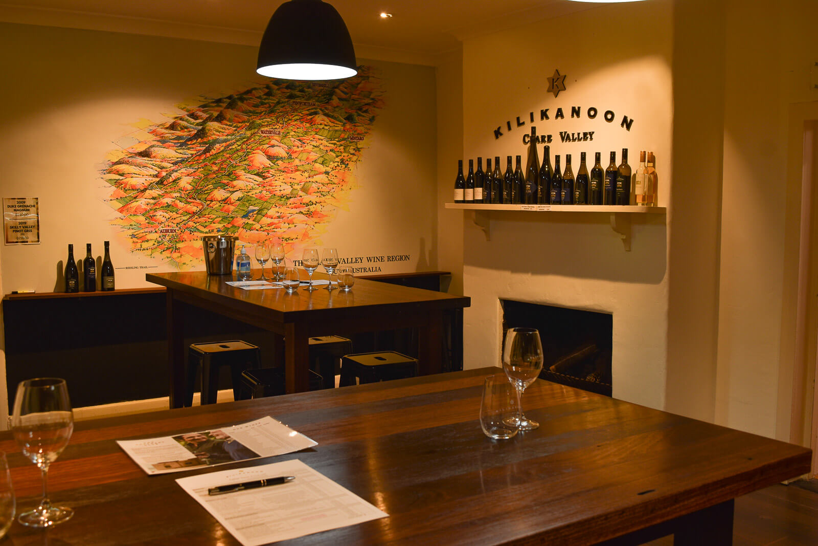 A tasting room with a map on the wall and glasses of wine 