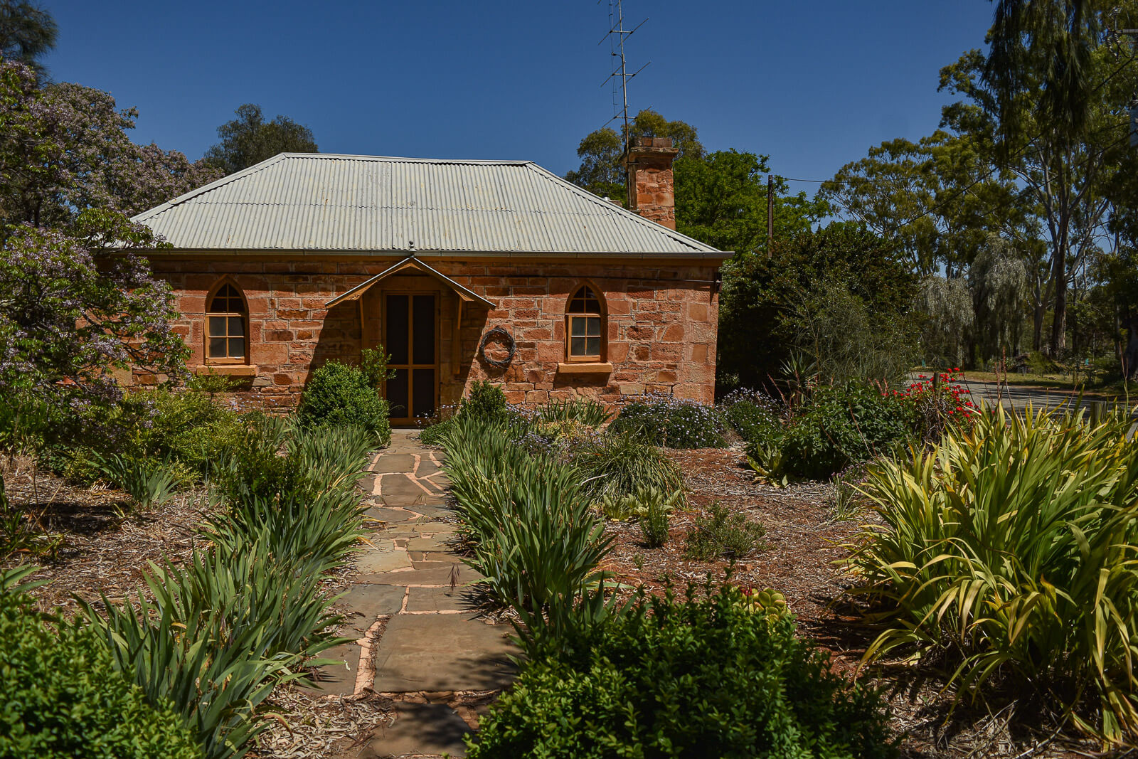 A stone cottage with colourful gardens