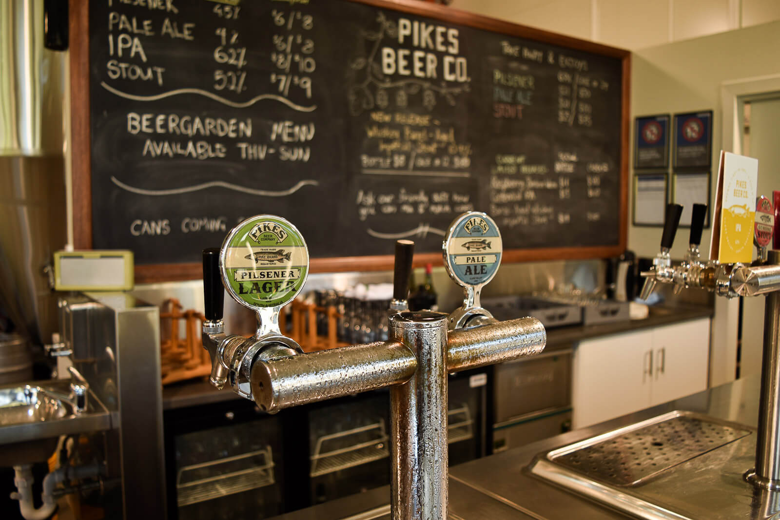 Beer on tap with a blackboard behind at Pikes Brewery