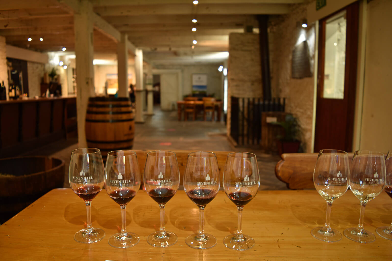 6 glasses filled with red wine in a tasting room