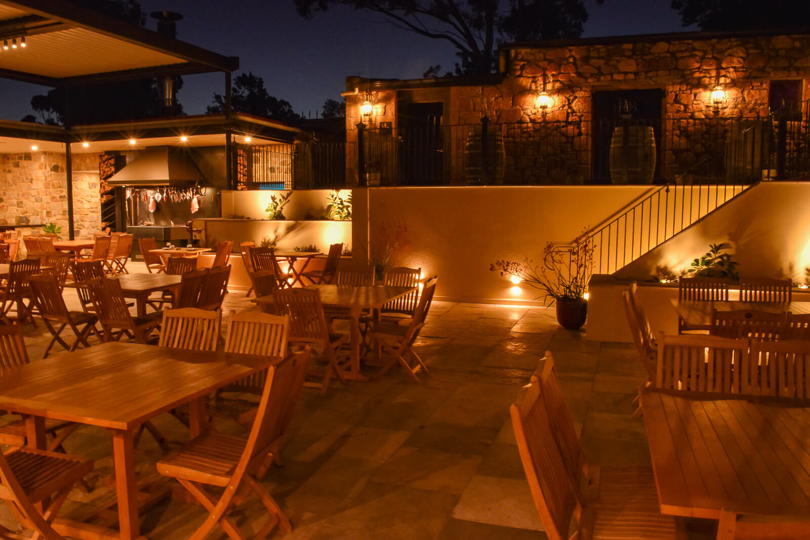 A lit courtyard with lots of tables and chairs