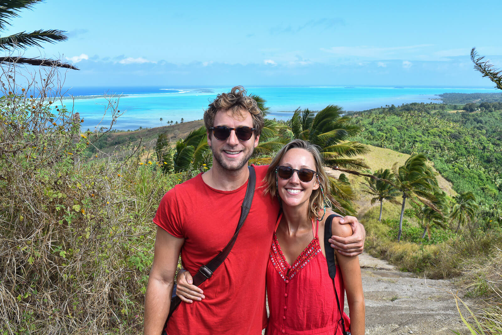 Hayley and Enrico standing on a hill with a blue lagoon in the background