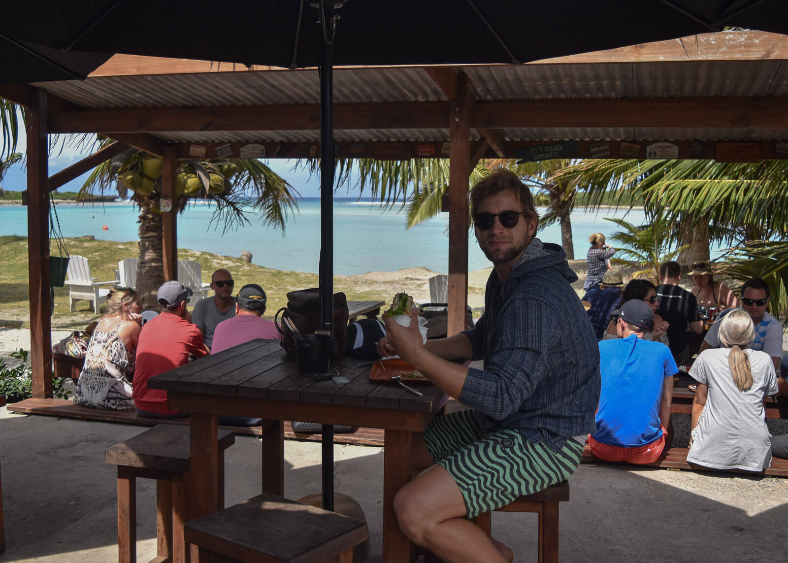 Enrico eating a fish sandwich at a waterfront cafe