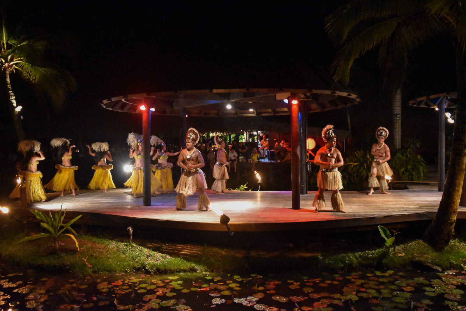 Polynesian dancers on a stage in grass skirts and costume