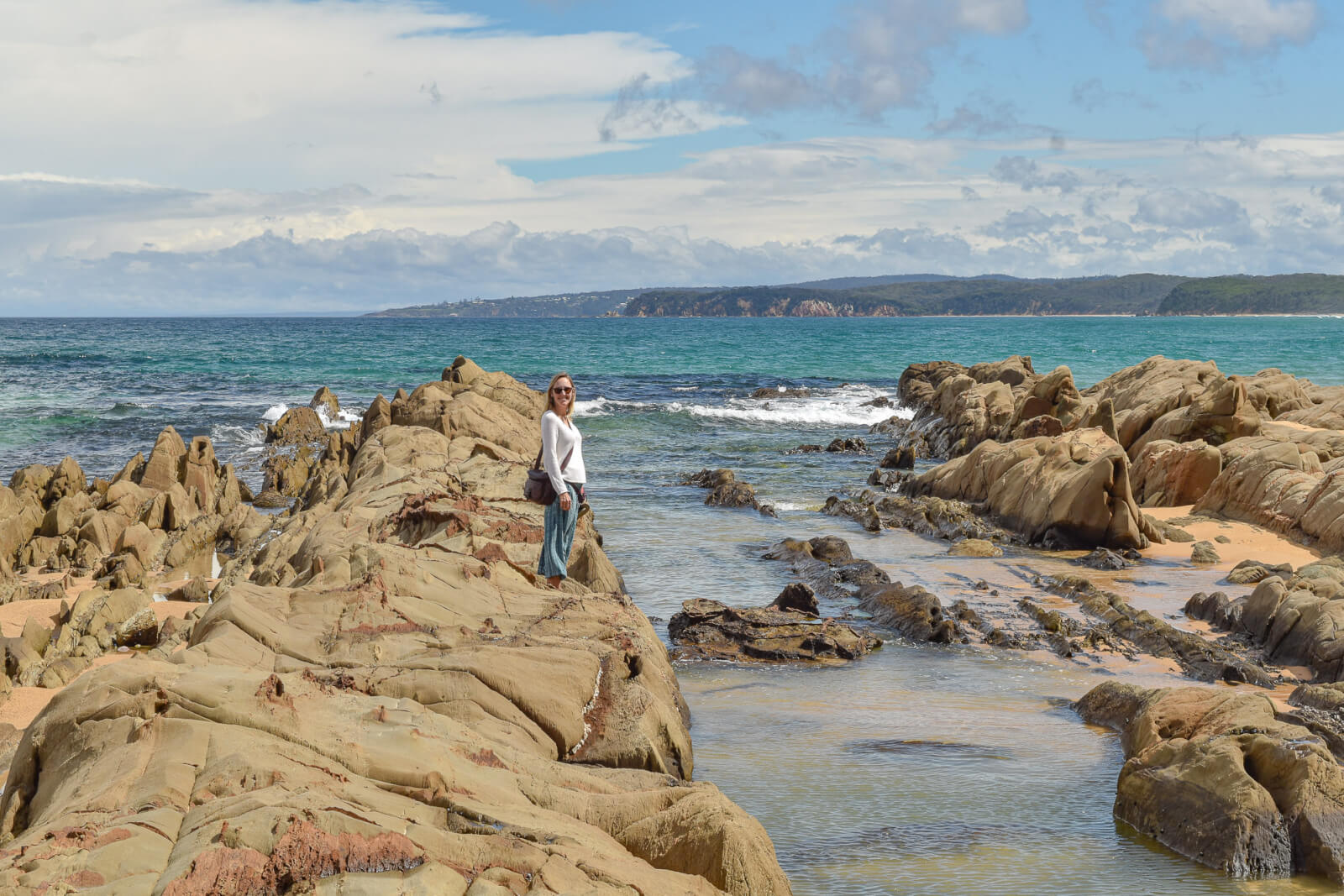 Hayley standing on rocks overlooking rock pools 