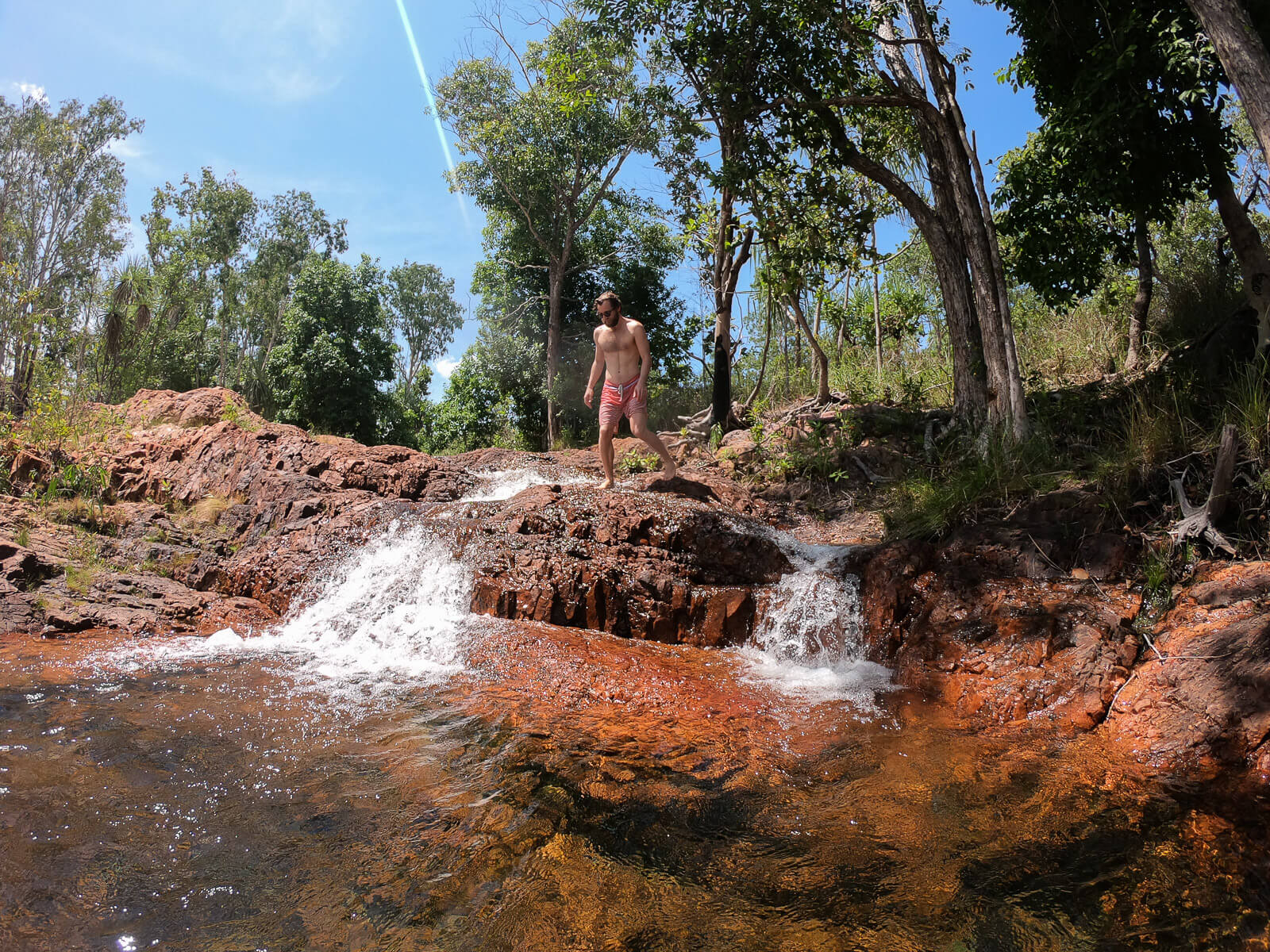 Enrico standing on rocks as water cascades into the pool below