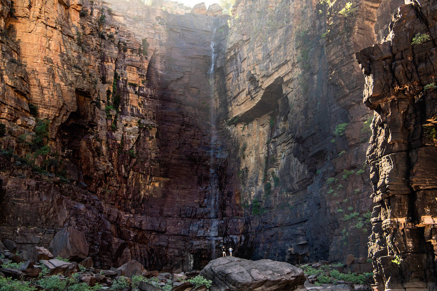 Visitors dwarfed by the large scale of Jim Jim Falls in Kakadu.<br /><br />Covering nearly 20,000 square kilometres, Kakadu National Park is teeming with wildlife, home to important Aboriginal rock art sites, and takes in diverse and exotic landscape.