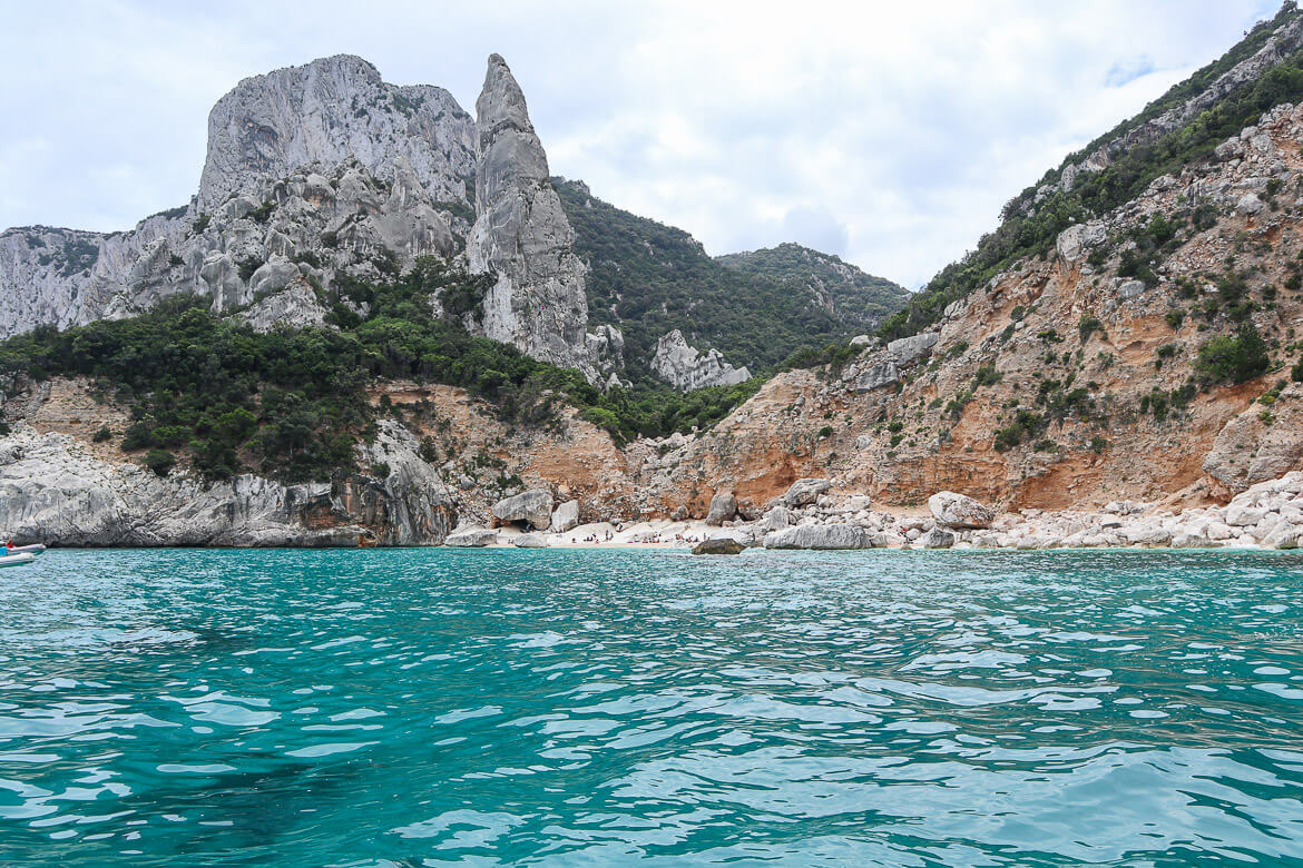 Rocky limestone formations on the white sand beach of Cala Goloritze