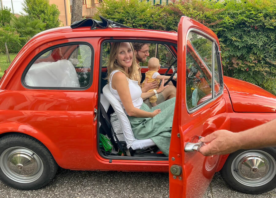 A vintage fiat 500 with a family inside in Italy