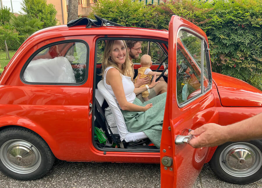 A vintage fiat 500 with a family inside in Italy