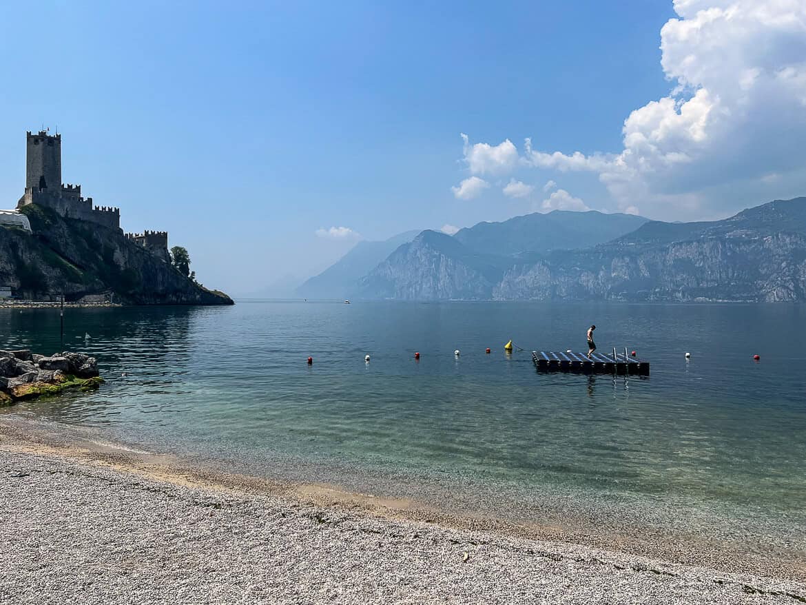A beach with a castle backdrop in Malcesine
