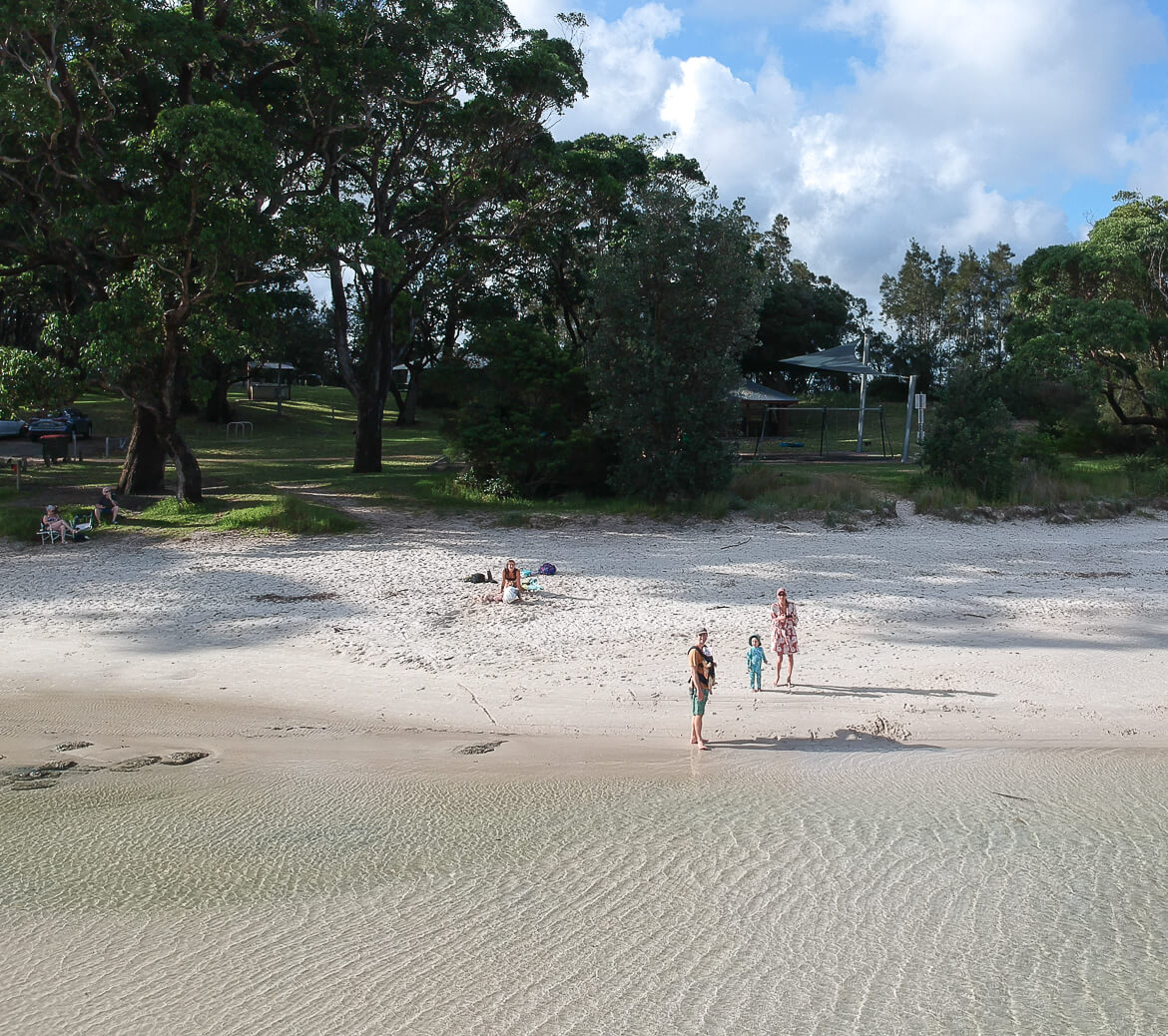 A family enjoying the shallow waters of Moona Moona Creek in Huskisson