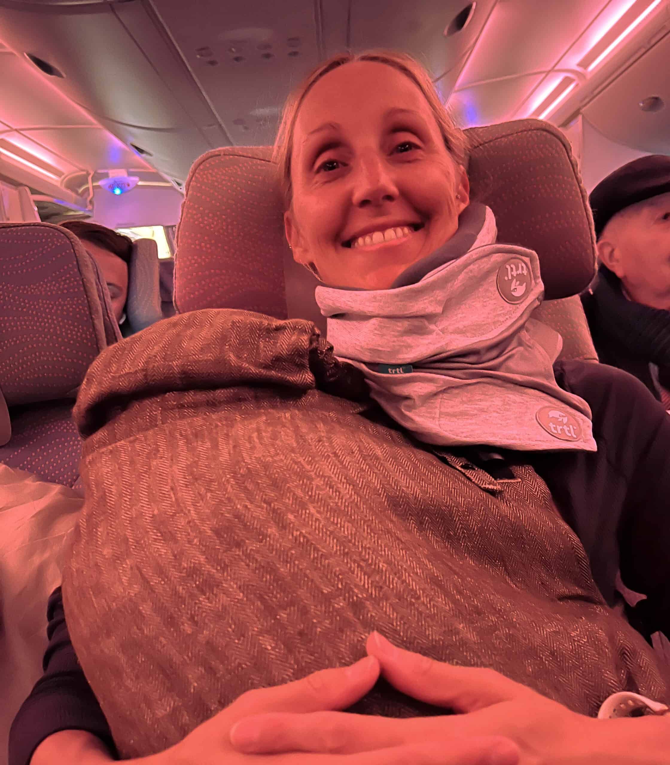 Wearing a travel pillow on a flight to London with a baby