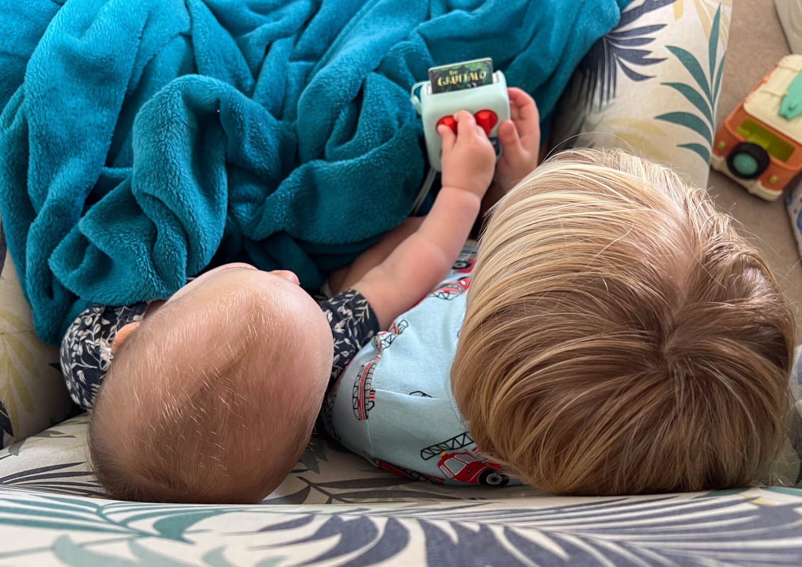 A baby and toddler playing with a Yoto