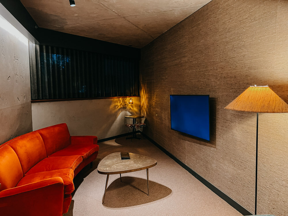 A hotel room with a sofa and mood lighting